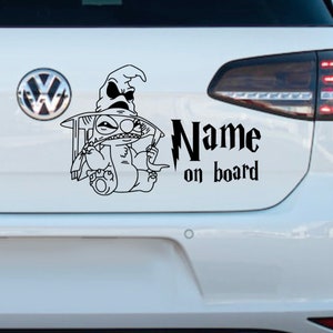 Op de afbeelding: Zwart-witte auto sticker met een cartoon Stitch-personage dat een zwarte tovenaarshoed draagt. De sticker zegt "Name on board" in een gestileerd lettertype.