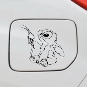 Op de afbeelding: Zwart-witte vinyl sticker met het stripfiguur Stitch die een benzinepomp vasthoudt. De sticker is ontworpen voor de tankklep van een auto en voegt een speels tintje toe aan het voertuig.