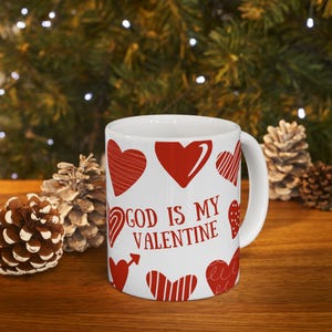 May include: White ceramic mug with red hearts and the text "God is my Valentine".
