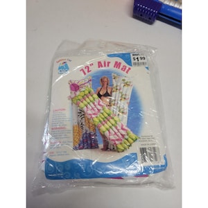 May include: A clear plastic package containing a 30 cm air mat. The mat features a floral design with pink and yellow accents. The package has the text "Summer Fun" and "Air Mat".