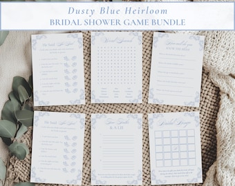 Op de afbeelding: Een set van zes witte papieren kaarten voor een bruidsdouche-spelbundel genaamd Dusty Blue Heirloom. De kaarten zijn voorzien van stoffige blauwe bloemenranden en tekst, waaronder He Said She Said, Word Search, How Well Do You Know The Bride, Two Truths & A Lie en Bridal Bingo.