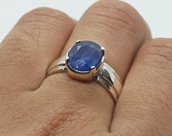 May include: A silver ring with a large, oval-shaped blue sapphire gemstone.