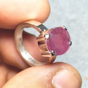 Peut inclure: Une bague en argent avec une grande pierre précieuse rose de forme ovale sertie à griffes.