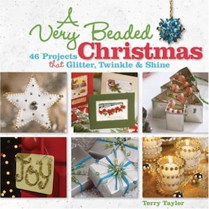 May include: A book cover with the title "A Very Beaded Christmas" and the subtitle "46 Projects that Glitter, Twinkle & Shine". The cover features a variety of beaded Christmas crafts, including a star, a Christmas tree, a gift box, and candles.