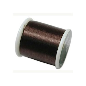 May include: A spool of dark brown sewing thread wound tightly around a cylindrical core. The spool features white plastic end caps on both sides, providing a clean contrast to the deep brown color of the thread wrapped evenly across the center.
