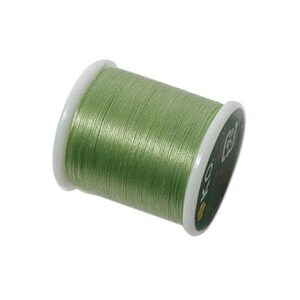 May include: A spool of light green sewing thread wound tightly around a white plastic core. The spool features white circular end caps, with the text KD visible on the side label. The thread has a smooth, slightly reflective texture.