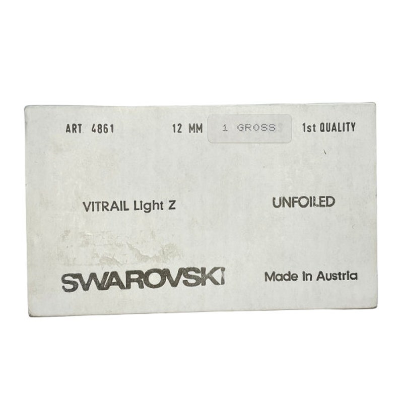 K&ouml;nnte beinhalten: Eine wei&szlig;e Box mit schwarzem Text, der "ART. 4861", "12 MM", "1 GROSS", "1st QUALITY", "VITRAIL Light Z", "UNFOILED", "SWAROVSKI" und "Made in Austria" lautet.