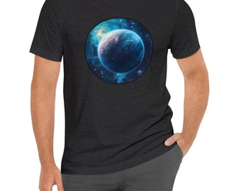 Puede incluir: Una camiseta gris oscuro jaspeada con un gráfico circular de un planeta azul en el espacio. El planeta está rodeado de estrellas y una nebulosa.
