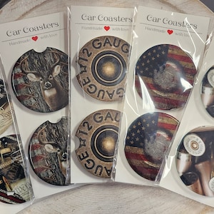 May include: Set of six car coasters with various designs, including a deer in the woods, a 12 gauge shotgun shell, and an American flag. The coasters are handmade with love and are perfect for adding a touch of personality to your car.