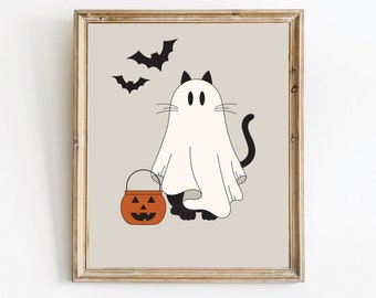May include: A framed wall art print featuring a black cat wearing a white ghost costume, holding an orange jack-o'-lantern candy bucket. Two black bats are flying above the cat against a light beige background, all enclosed in a wooden frame.
