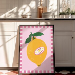 Cheerful hand drawn lemon illustration with playful easy peasy typography, bright yellow citrus fruit wall art in dopamine art style, modern kitchen print with quirky lettering and fun fruit doodles, maximalist summer decor featuring bold colors and happy vibes, trendy food art perfect for kitchen gallery wall, retro inspired fruit illustration with positive message, funky home decor with fresh citrus theme