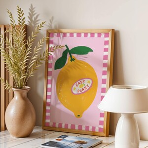 Cheerful hand drawn lemon illustration with playful easy peasy typography, bright yellow citrus fruit wall art in dopamine art style, modern kitchen print with quirky lettering and fun fruit doodles, maximalist summer decor featuring bold colors and happy vibes, trendy food art perfect for kitchen gallery wall, retro inspired fruit illustration with positive message, funky home decor with fresh citrus theme
