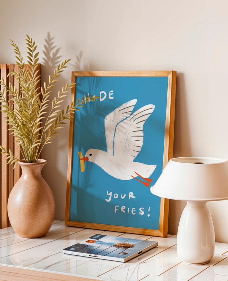 A cheeky seagull eyes a pile of fries in this vibrant, maximalist illustration, bursting with bold colors and playful text warning to protect your snacks. Perfect for adding a humorous coastal vibe to kitchens, beach house nooks, or sunny living spaces. Quirky vacation art, funny home accent, dopamine decor gift, coastal wall hanging, playful beachy print. Ideal for fry-loving friends or anyone craving a lighthearted, maximalist touch to their decor. Frame it for a pop of joy in any room.