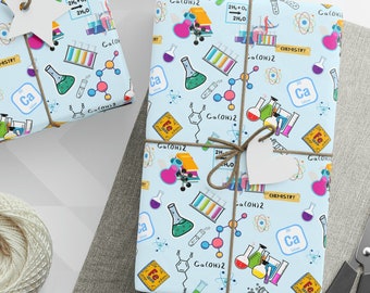 May include: Blue wrapping paper with a science theme. The paper is covered in colorful beakers, test tubes, molecules, and the words "Ca(OH)2" and "Chemistry".