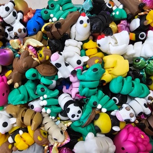 May include: A collection of colorful, small, plastic animal figurines. The figurines are in various poses and include a cow, chicken, turtle, panda, and frog.