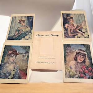 May include: A collection of vintage art prints and a booklet titled "Charm and Beauty." The prints feature portraits of women in elegant attire, with soft color palettes and floral accents. The booklet is open, revealing text and a blank space.