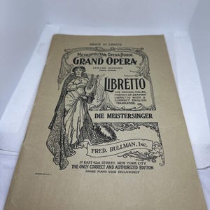 Puede incluir: Un folleto vintage de color beige con texto e ilustraciones en negro. El folleto se titula "Grand Opera" y presenta la ópera "Die Meistersinger". El folleto está a la venta por 35 centavos.