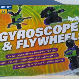 May include: A colorful box for a Gyroscopes & Flywheels experiment kit. The box features illustrations of gyroscopic vehicles in black, green, and purple. Text includes "Build gravity-defying gyroscopic vehicles" and "Explore the physics of rotational motion."