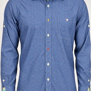 May include: A blue long-sleeve button-down shirt featuring a subtle multi-colored dash pattern, a single chest pocket, and a contrasting patterned fabric lining on the inner collar and cuffs. The shirt includes white buttons and two distinct accent buttons.