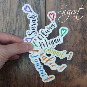 May include: A set of colorful personalized stickers with names written in cursive script and a balloon heart design. The names are Sarah, Olivia, Megan, Abigail, Julie, and Lauren.
