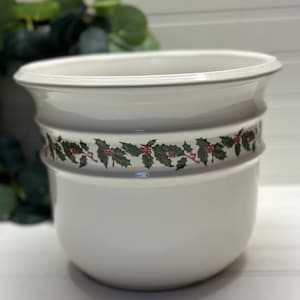 May include: White ceramic planter with a green holly and red berry design around the top edge.