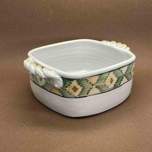 Puede incluir: Plato para hornear de cerámica blanca con un patrón geométrico verde y marrón y asas con forma de cuerda.