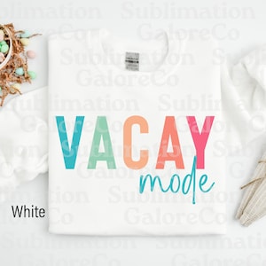 以下が含まれることがあります： 白いクルーネックのトレーナーに「VACAY mode」という文字がカラフルな文字で書かれています。文字は青、緑、オレンジ、ピンクの色合いです。
