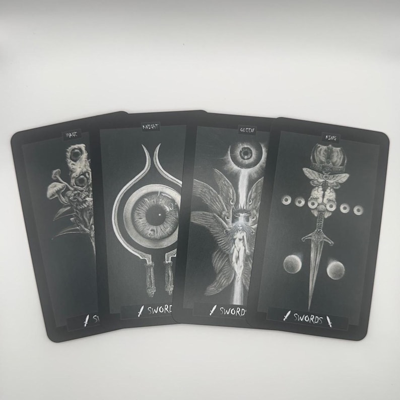May include: Four black tarot cards with white illustrations. The cards feature detailed drawings of surreal imagery, including eyes, figures, and floral elements. Each card has a title and the word "SWORD" or "SWORDS" at the bottom.