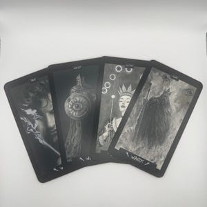 May include: Four tarot cards with black borders and grayscale illustrations. The cards feature images of a person, a knight with a shield, a queen with a scepter, and a cloaked figure. The word "WANDS" is visible on one card.