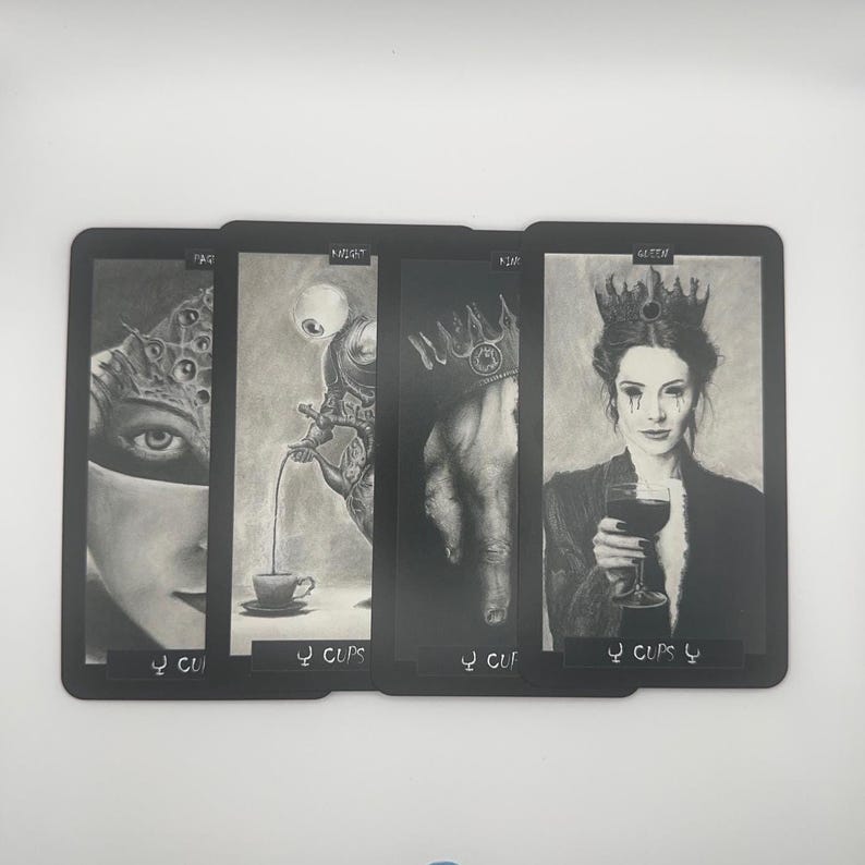 May include: A set of four tarot cards with black borders. Each card features a detailed grayscale illustration. The cards are labeled "PAQ", "NIGHT", "ASH", and "QUEEN", with the suit "Cups" at the bottom. The artwork has a gothic, fantasy theme.