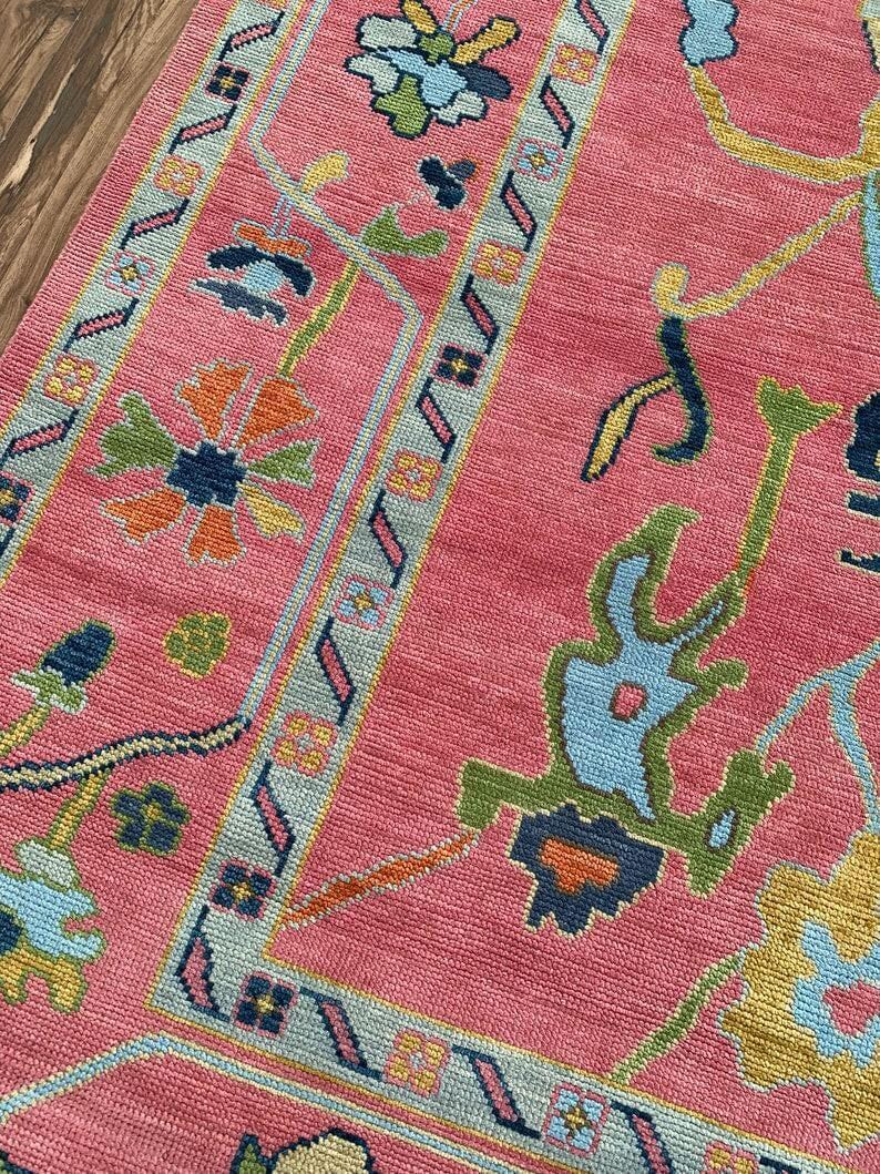 Handmade oriental pink rug with multicolor flowers and vines.