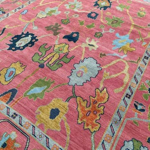 Bright pink bohemian wool rug with traditional oriental flower pattern.