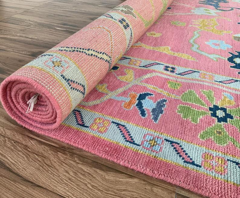 Traditional oriental pink rug with oversized flowers and vine patterns.