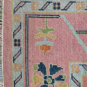 Bright pink wool rug with colorful oriental design for modern bohemian homes.