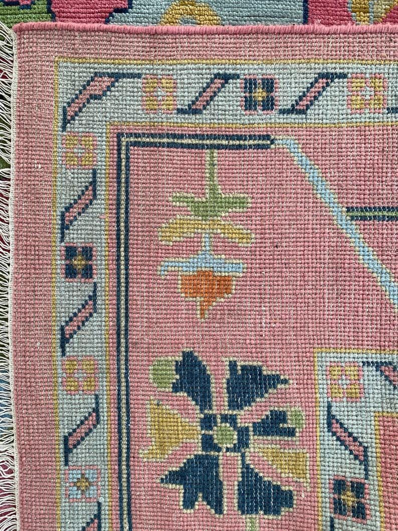 Bright pink wool rug with colorful oriental design for modern bohemian homes.