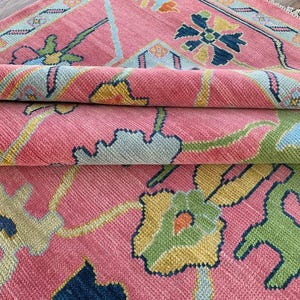 Handmade pink oriental floral rug with multicolor design for living room decor.