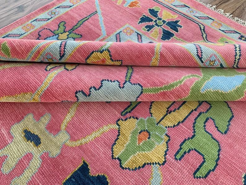 Handmade pink oriental floral rug with multicolor design for living room decor.
