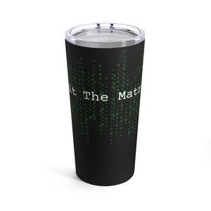 May include: A black stainless steel tumbler with a green and white design. The tumbler features a digital pattern of ones and zeros with the text "At The Matrix" in white.