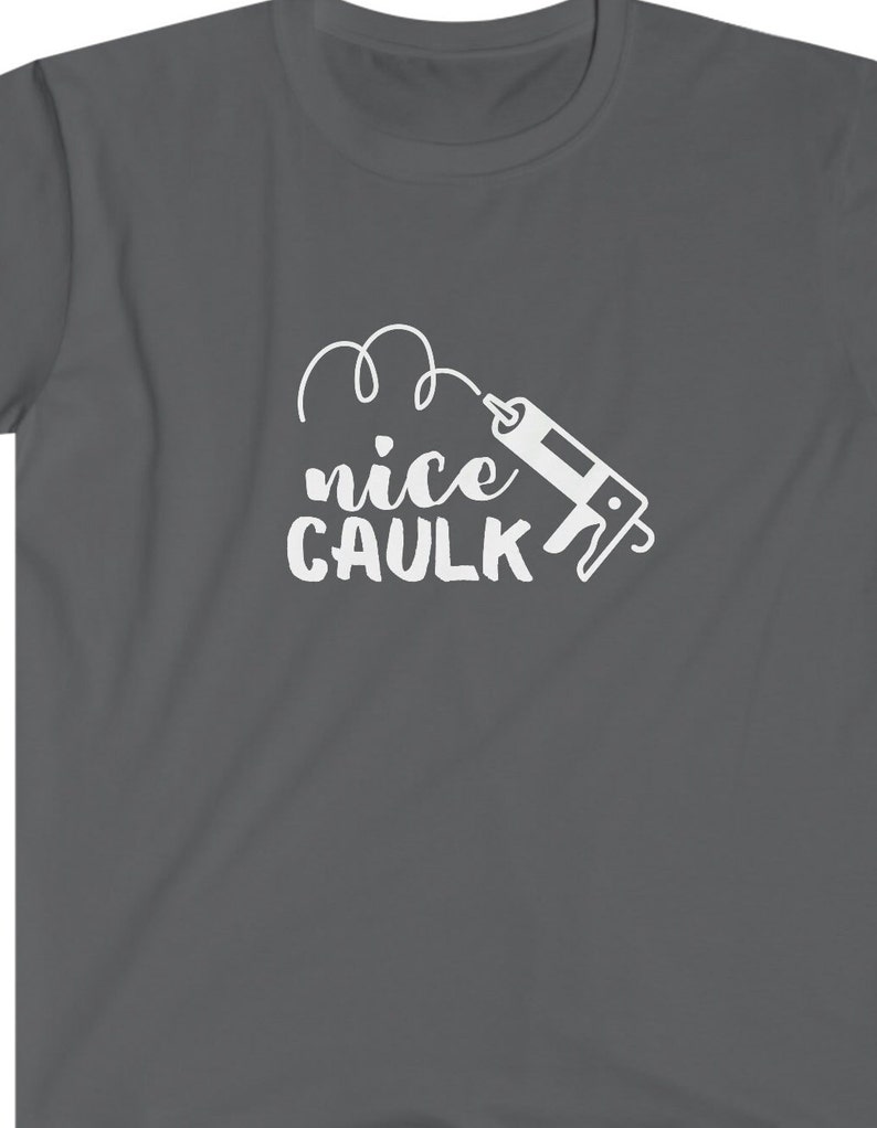 K&ouml;nnte beinhalten: Ein dunkelgraues T-Shirt mit einer wei&szlig;en Grafik einer Kartuschenpistole und dem Text "nice caulk" in einer verspielten Schrift.