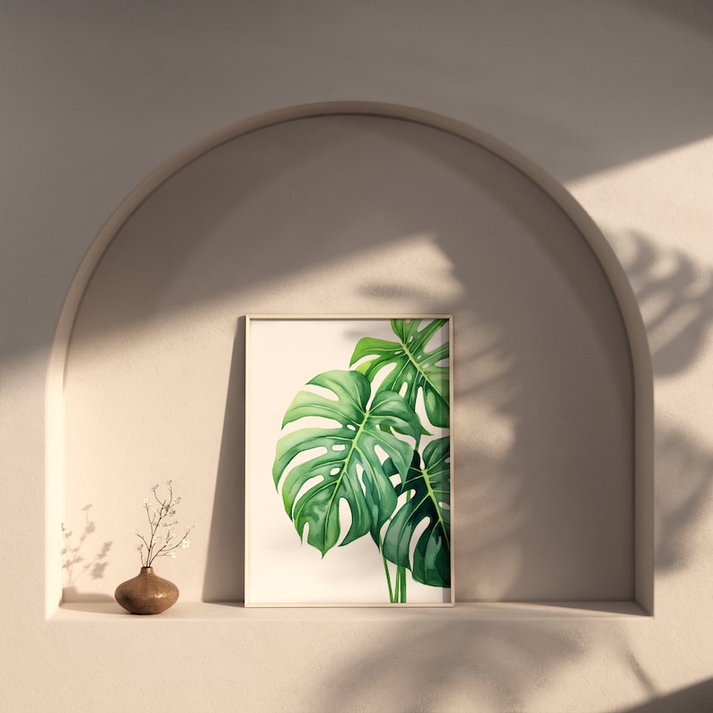May include: A framed print of a watercolour painting of a monstera leaf in shades of green against a white background.