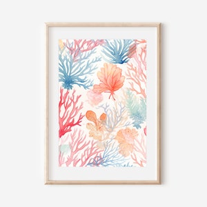 Pode incluir: Uma impressão em aquarela emoldurada com uma vibrante cena subaquática. A obra de arte apresenta uma variedade de corais e plantas marinhas em tons de vermelho, azul e pêssego sobre um fundo creme. A moldura é de madeira clara.