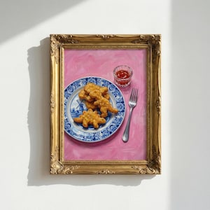 K&ouml;nnte beinhalten: Gerahmtes Gem&auml;lde mit einem blau-wei&szlig;en Teller mit Dinosaurier-Nuggets. Ein kleines Glas Ketchup und eine Gabel liegen neben dem Teller auf einem rosa Hintergrund. Das Gem&auml;lde befindet sich in einem goldenen, verzierten Rahmen.