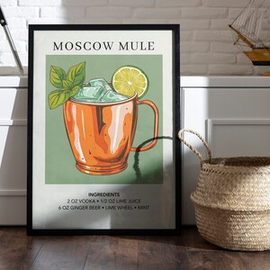 May include: A framed poster with a green background and a drawing of a Moscow Mule cocktail in a copper mug. The ingredients are listed below the image: 2 oz vodka, 1/2 oz lime juice, 6 oz ginger beer, lime wheel, and mint.