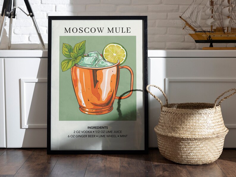 May include: A framed poster with a green background and a drawing of a Moscow Mule cocktail in a copper mug. The ingredients are listed below the image: 2 oz vodka, 1/2 oz lime juice, 6 oz ginger beer, lime wheel, and mint.