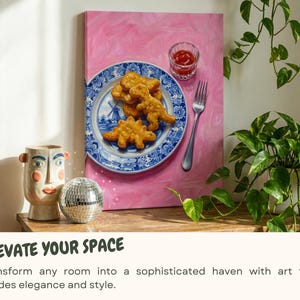 K&ouml;nnte beinhalten: Ein rosa Leinwandkunstwerk zeigt einen blau-wei&szlig;en Teller mit Dinosaurier-f&ouml;rmigen Chicken Nuggets, einem kleinen Glas Ketchup und einer Gabel. Eine dekorative Vase und eine Discokugel stehen auf einer Holzoberfl&auml;che. Der Text "ELEVATE YOUR SPACE" ist sichtbar.