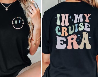 Puede incluir: Camiseta negra con un gráfico de arcoíris que dice "In My Cruise Era" en la espalda y una carita sonriente con un rayo en la parte delantera.