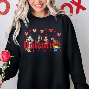 May include: Black sweatshirt with a red "Valentine" graphic featuring characters from the Toy Story franchise holding red heart balloons.