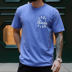 May include: A blue t-shirt with a white circle graphic that says "Cool Dads Club".