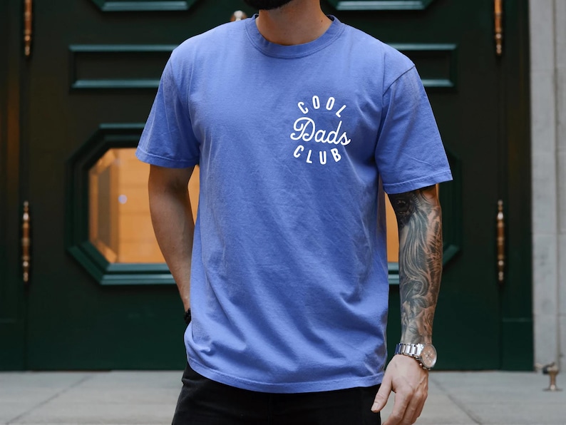 May include: A blue t-shirt with a white circle graphic that says "Cool Dads Club".