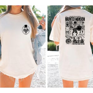 May include: White t-shirt with a black and white graphic of a ghost on the front and a black and white graphic of the Haunted Mansion on the back. The graphic on the back includes the text "Welcome Foolish Mortals" and "Haunted Mansion".
